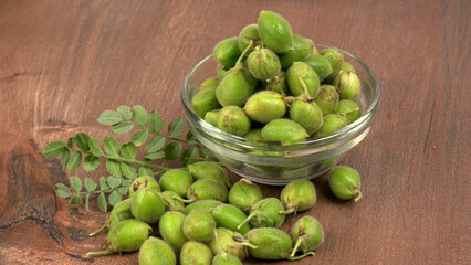 Fresh Green chickpeas on a branch, and in the pod, isolated on wooden background.