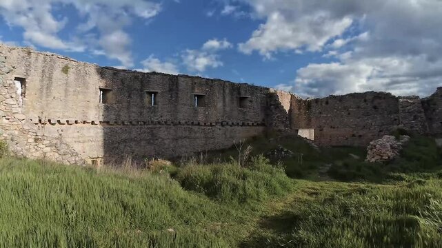 Medieval stone tower rising above castle ruins under blue sky