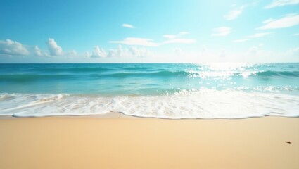 Fototapeta premium Gentle waves washing onto a sandy beach under a bright blue sky with scattered clouds