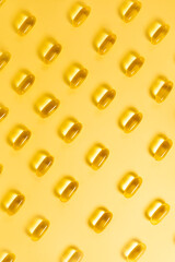 Fish oil capsules Omega-3 vitamins on a yellow background