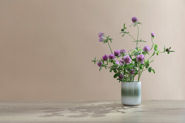 still life with clover  in ceramic cup  on wooden table