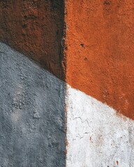 Abstract close up of painted concrete wall with geometric shapes in orange gray and white colors