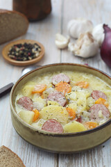 A bowl with traditional German potato soup with sausages