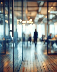 Modern office interior with glass walls and wooden floor, people walking in background, blurred perspective, daytime