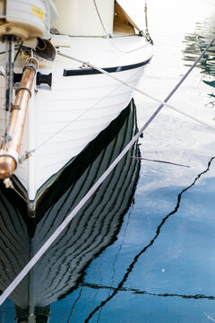 Restored wooden clinker built couta boat with reflection