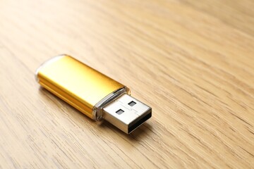 One flash drive on wooden background, closeup. Space for text