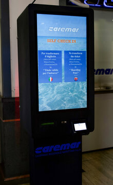 Naples, Italy - April 23, 2025: Caremar self check-in kiosk located in terminal, featuring digital screen displaying instructions in Italian and English
