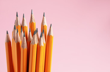 Sharp graphite pencils on pink background, closeup. Space for text