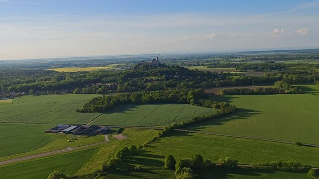 Aerial panoramic view of Kuneticka Hora Castle in Central Bohemia, surrounded by spring landscape and farmlands.