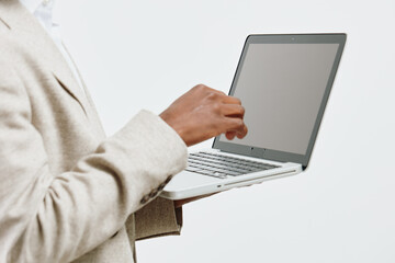 Businesswoman using laptop computer in office, professional work environment, modern technology, casual attire, neutral background, focused on digital device, workspace setup, professional lifestyle