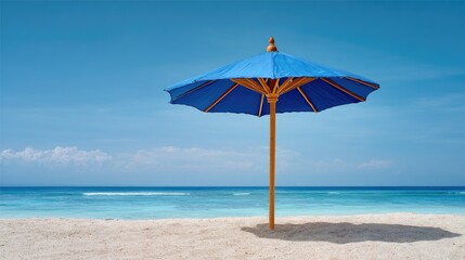 Blue umbrella on a sandy beach with clear sky and ocean in the background, representing vacation and relaxation