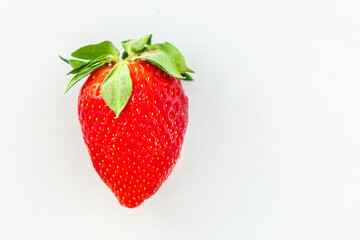 Fresh red strawberry highlighting vibrant color against a white background