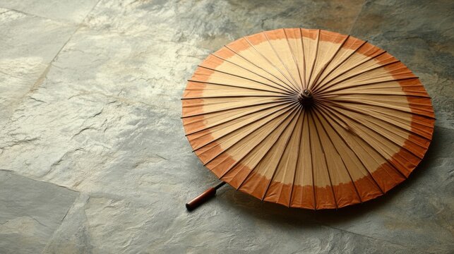 A traditional Chinese umbrella made of oiled paper, displayed closed on a neutral floor 