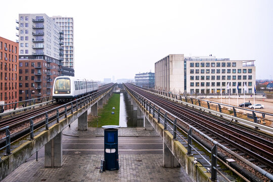 Elevated metro railway crossing through &Oslash;restad&rsquo;s urban landscape. Central perspective and symmetry define this minimalist image of infrastructure and contemporary mobility.