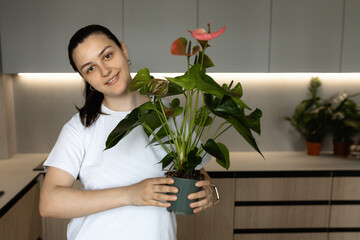 A young girl holds a potted houseplant, showcasing fresh. This natural, eco-friendly image highlights home interior, gardening, and positive growth. Perfect for lifestyle, domestic, and floral themes.