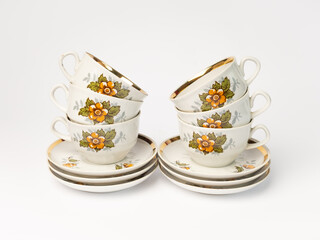 VIntage ceramic coffee cups with saucers stack, isolated on white background with copy space. Rustic style ceramics.