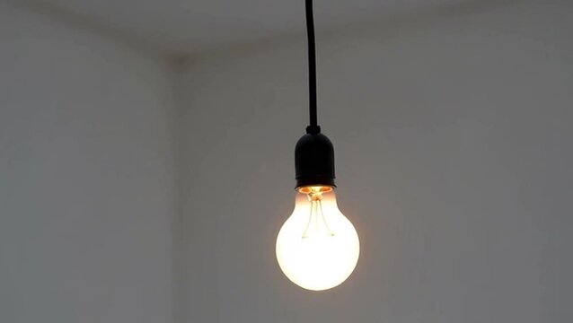 Single lit light bulb hanging in minimalist room &ndash; creativity, innovation and bright idea concept