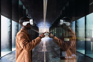 Young man wearing vr headset is exploring virtual reality metaverse and touching digital screen