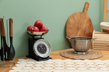 Kitchen scale, products and cooking utensils on wooden table