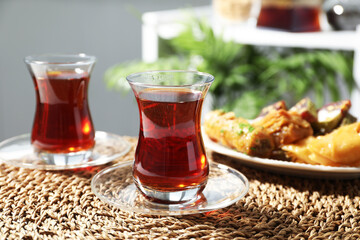 Traditional Turkish tea in glass cups and sweets on table, closeup