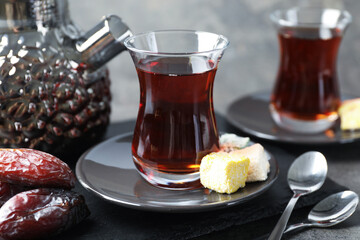 Tasty Turkish tea served with sweets on grey table, closeup
