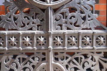 Symmetrical metal gate in historic archway. Old-world charm and decorative fence style.