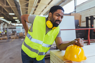 Employee In Safety Gear Experiencing Discomfort in an Indoor Workspace