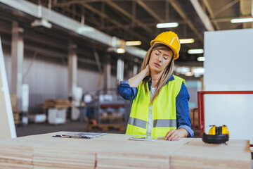 Construction Worker Experiencing Neck Pain in a Busy Industrial Warehouse