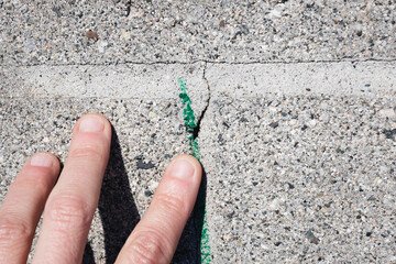 Hand pointing to marked out cracked mortar joint. Made by a structural engineer, building inspector...