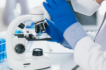 Scientist working microscope doing research in laboratory. Scientist in a lab, adjusting a...
