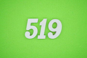 The numbers are made of white painted wood and placed on a green paper background.
