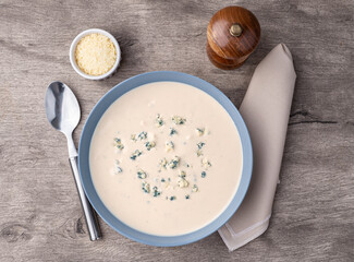 Cheese soup in a bowl over wooden table