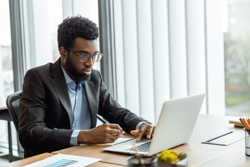 Obraz premium Elegant businessman working in his office and having a business video call