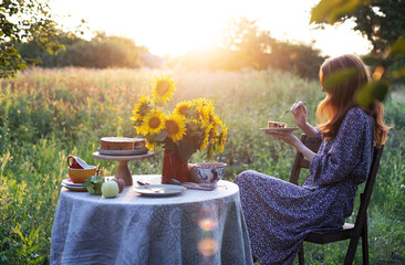 girl sits in the garden and eats a pie