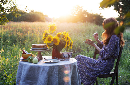 girl sits in the garden and eats a pie
