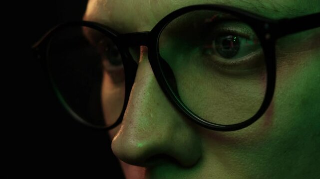 Close-up of tired man's face with greenish skin tone, eyes reflect trading chart on screen, symbolizing exhaustion from excessive screen time and market analysis