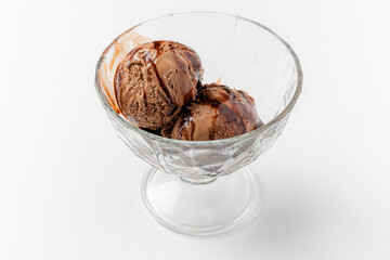 Two luscious scoops of chocolate ice cream topped with a drizzle of syrup create a tempting dessert