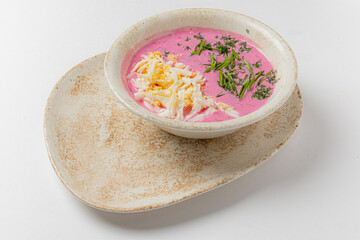 Vibrant beetroot soup topped with cheese and fresh herbs for a colorful delight