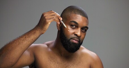 Serum, beauty and portrait of black man in studio for salon, grooming and dermatology. Cosmetics,...