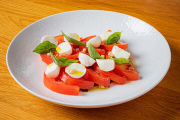 Bright red tomatoes and soft mozzarella create a delightful caprese salad adorned with fresh basil