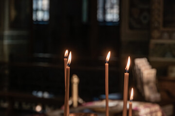 Church sanctuary with seven unlit candles arranged symmetrically, under filtered natural light...