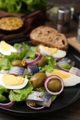 Delicious salad with herring, egg, mustard and vegetables on table, closeup