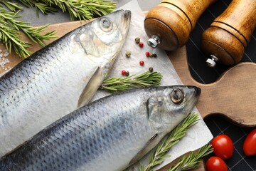 Salted herrings, spices and tomatoes on table, flat lay