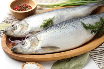 Salted herrings and spices on white table, closeup