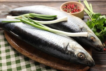 Salted herrings and spices on wooden table, closeup
