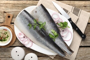 Tasty herring fillets with spices on wooden table, flat lay