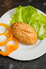 Savory croquette topped with a crispy coating accompanied by fresh lettuce and bell pepper