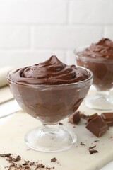 Delicious chocolate pudding in dessert bowls on white table, closeup