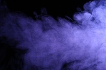 Beautiful smoke in purple light on dark background