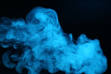 Beautiful smoke in blue light on dark background